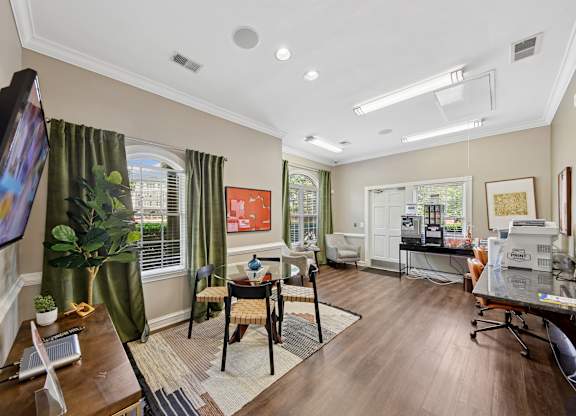 A living room with a television, a chair, a table, and a potted plant.
