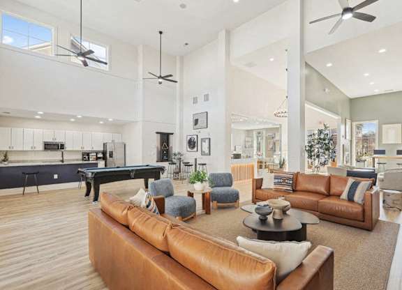 A modern living room with a pool table and a variety of seating options.