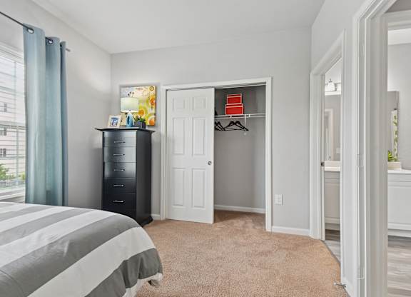 A bedroom with a bed, a dresser, and a wardrobe.