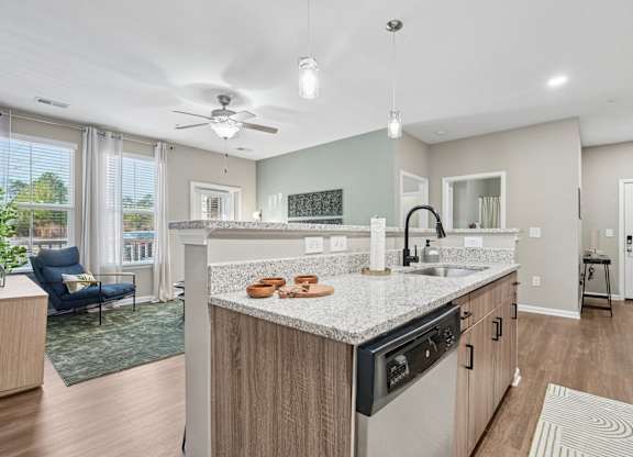 A modern kitchen with a large island and a ceiling fan.
