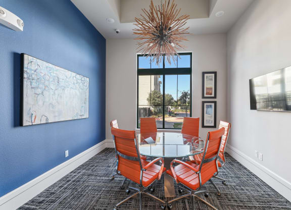 a dining room with a glass table and chairs and a large window