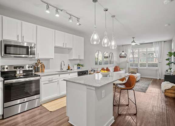 A modern kitchen with a white island and stainless steel appliances.