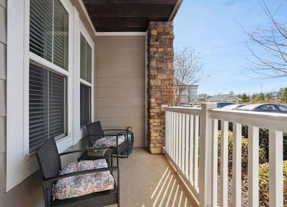 A balcony with a table and chairs.
