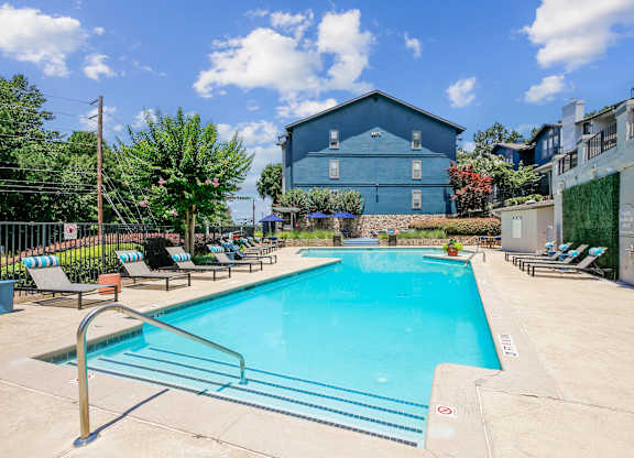 A blue building with a pool in front of it.