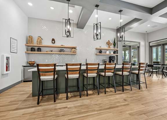 A modern dining room with wooden floors and a long table set with chairs.