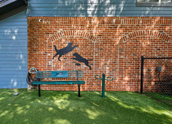 A dog silhouette is painted on a brick wall.