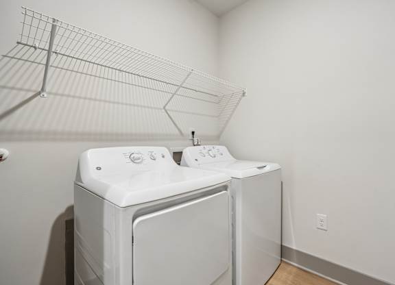 A white washing machine and dryer in a small room.