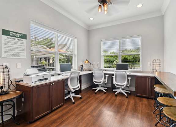 A well-lit office space with a desk, chairs, and a printer.