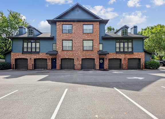 A large two-story building with a parking lot in front.