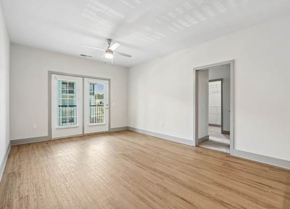 A room with a wooden floor and a ceiling fan.