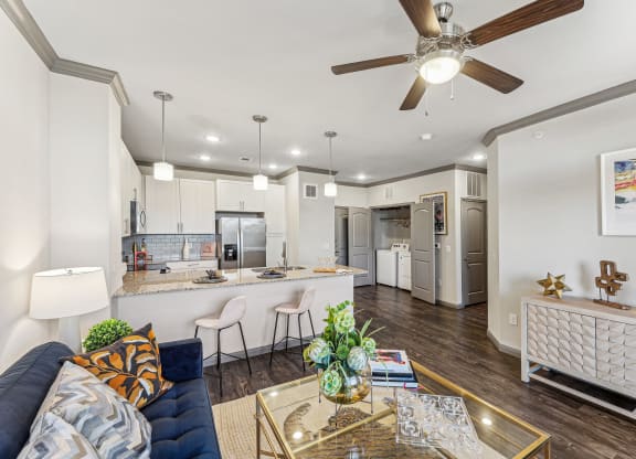 a living room and kitchen with a ceiling fan