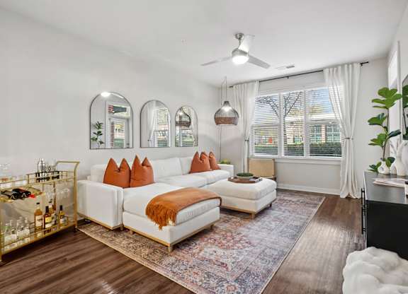 A living room with a white couch and a rug.