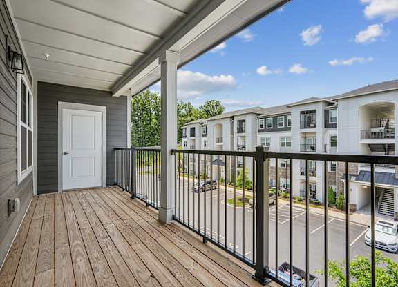 A balcony with a white door and a black railing.