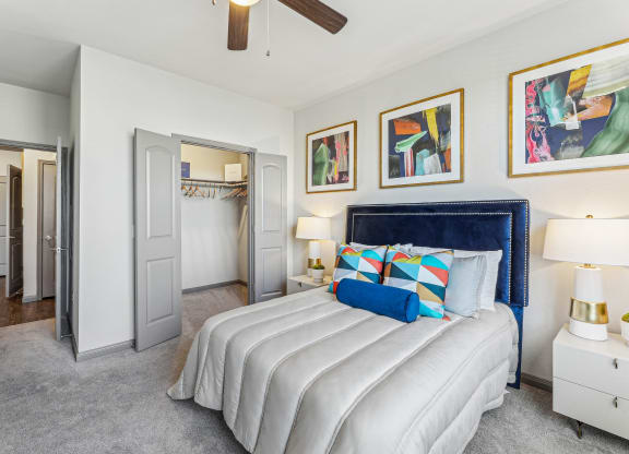 a bedroom with a large white bed and a ceiling fan