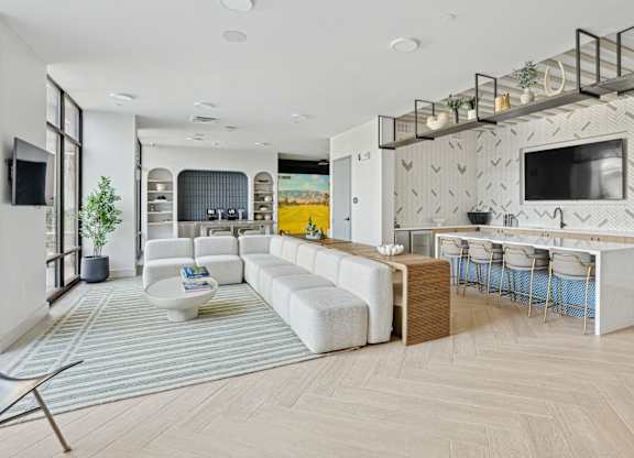 A modern open plan living and kitchen area with a white sofa set.