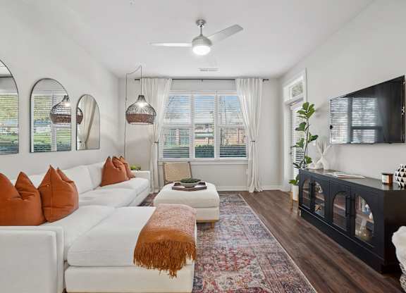 A living room with a white couch and a rug.