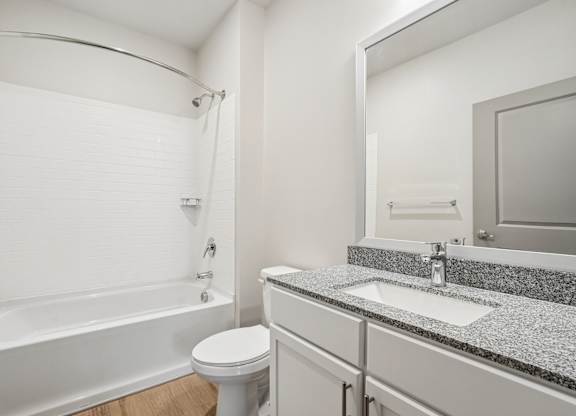 A white bathroom with a tub, toilet, and sink.