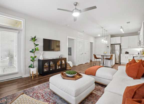 A living room with a white couch and a wooden coffee table.