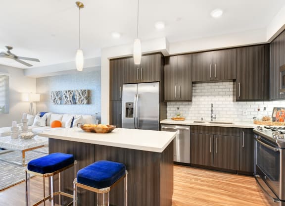Open kitchen and living room with a white counter top at Sola at Pacific Highlands Ranch Apartments, San Diego, CA