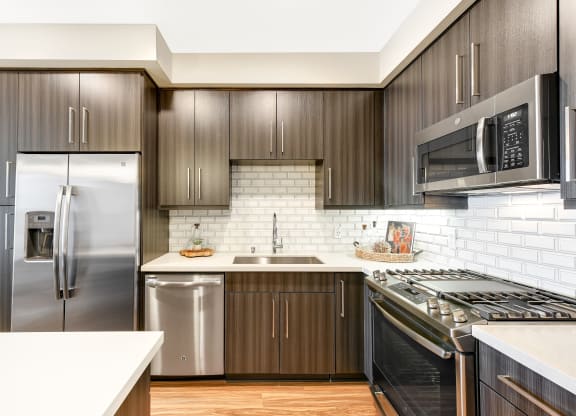 Kitchen with stainless steel appliances and wooden cabinets at Sola at Pacific Highlands Ranch Apartments, San Diego, 92130