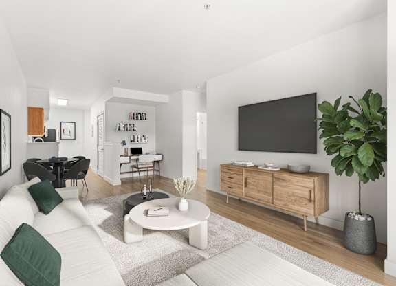 A modern living room with a white sofa, a coffee table, and a TV on the wall.