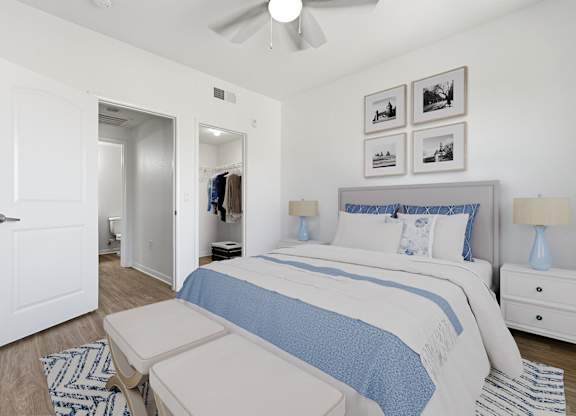A bedroom with a bed, nightstand, and a ceiling fan.