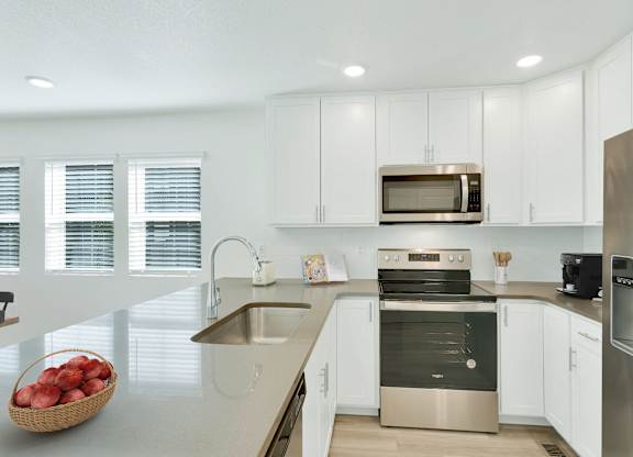 a kitchen with white cabinets and stainless steel appliances