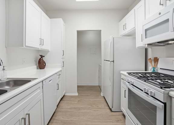A kitchen with white appliances and cabinets.