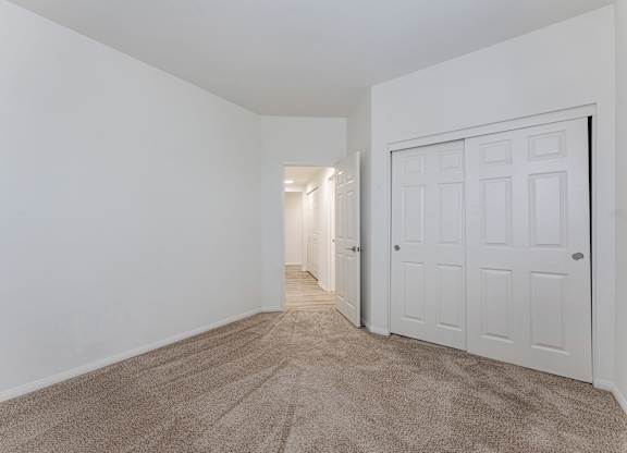 A room with a carpeted floor and a white door.