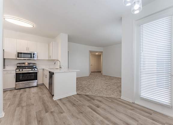 A kitchen with white cabinets and a microwave above the stove.