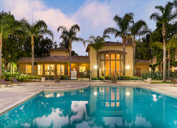 A house with a pool in front of it.