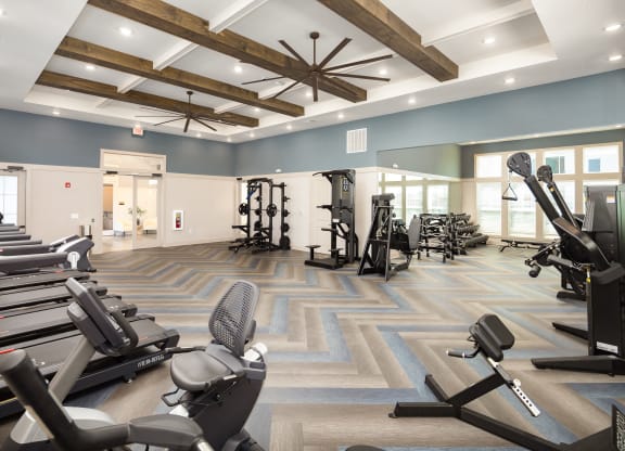 a gym with cardio machines and weights on the floor