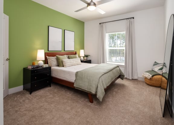 a bedroom with green walls and a white bed