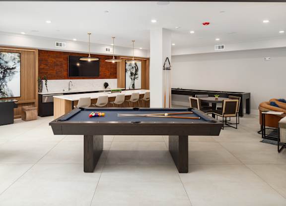 an open living room with a pool table and a bar