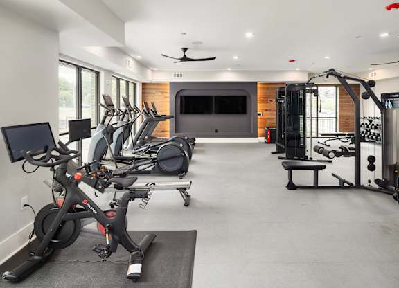 a gym with exercise equipment and a tv in the back