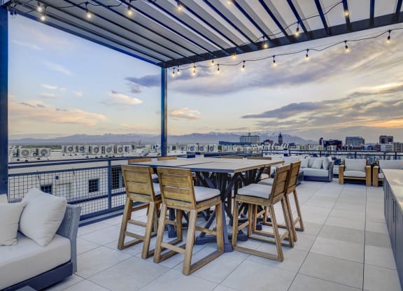 a terrace with a table and chairs and a view of the city