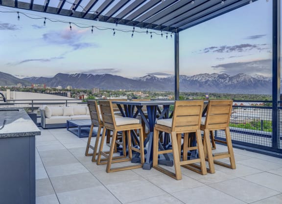 a patio with a table and chairs and a view of the mountains