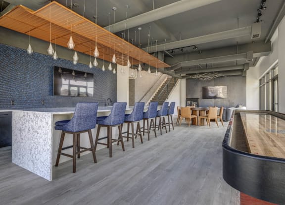 a lobby with bar stools and chairs and a bar with a counter