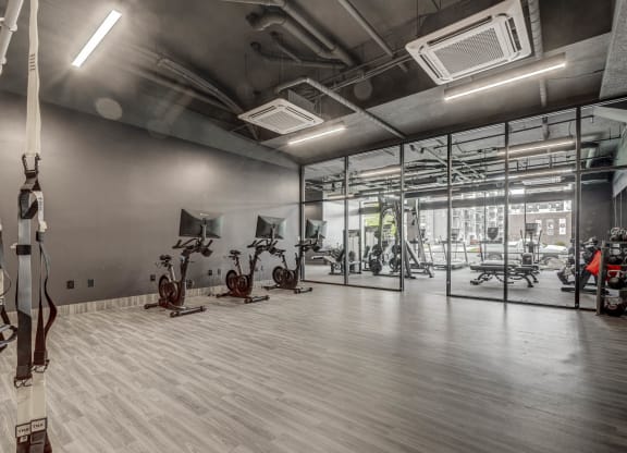 a gym with weights and exercise equipment in a glass walled room