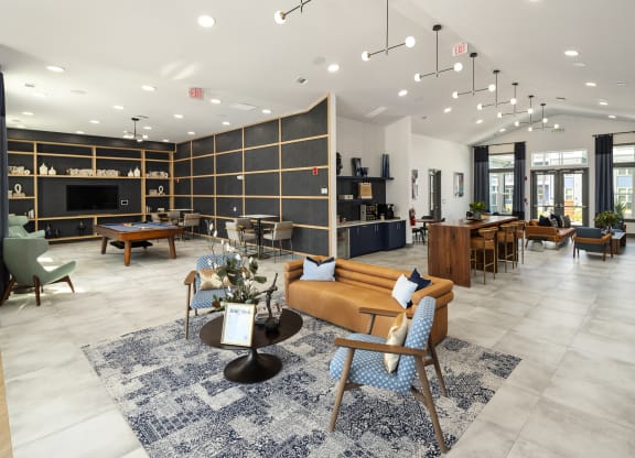 a lobby with couches tables and chairs and a pool table