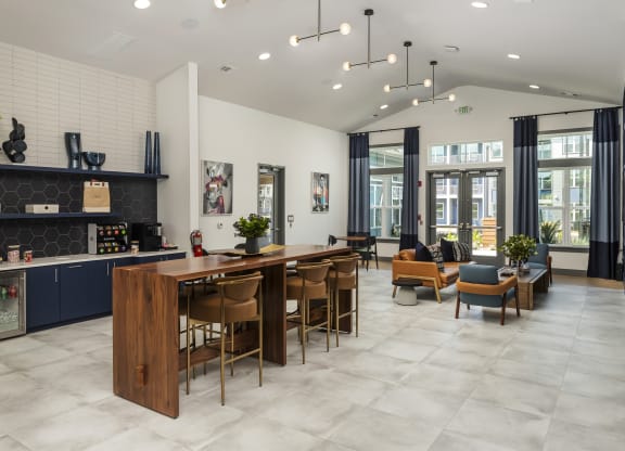 a communal area with a bar and chairs and a living room with a couch