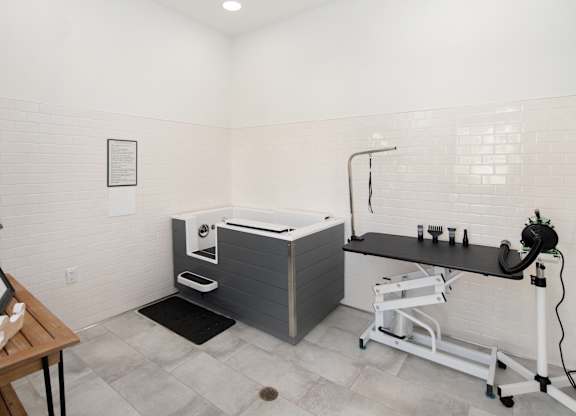 A bathroom with a white tub and a black counter.