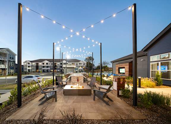 A park bench is under a string of lights.