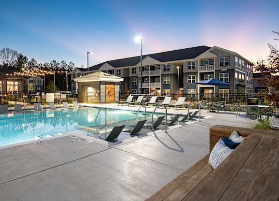 A large building with a pool in front of it.
