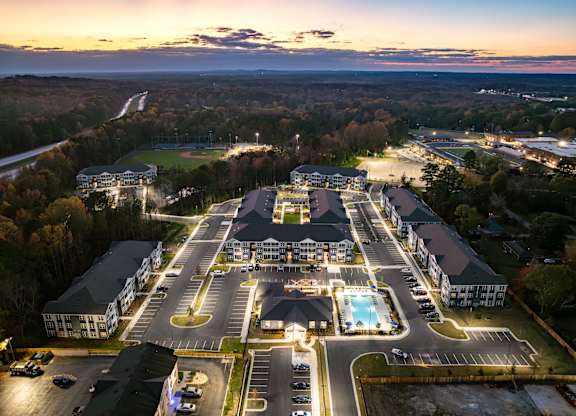A large resort with a swimming pool and a parking lot.