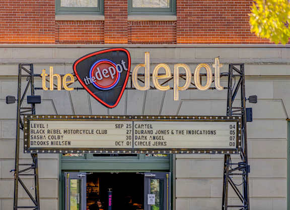A signboard for The Depot shows a series of dates and names.