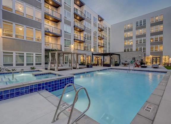 A large swimming pool in front of apartment buildings.