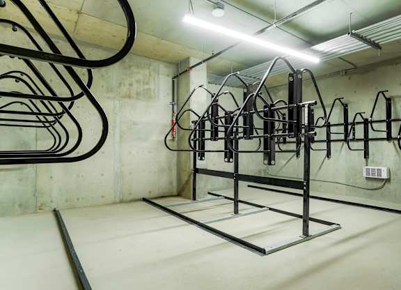 A gym with a white wall and a black cable machine.