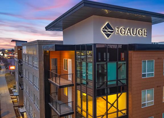 The GAUGE building is a modern multi-story structure with a mix of brick and wood paneling.
