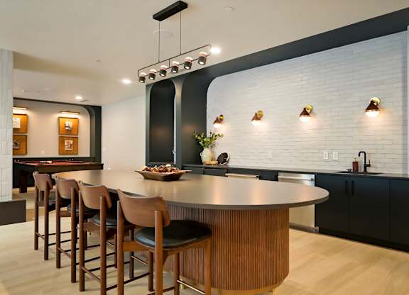 A modern kitchen with a large island and bar stools.